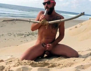 stud ravages himself on the beach with a wooden faux-cock