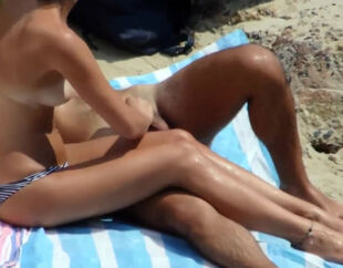 Bare young lady duo gets caught during hand job on the beach