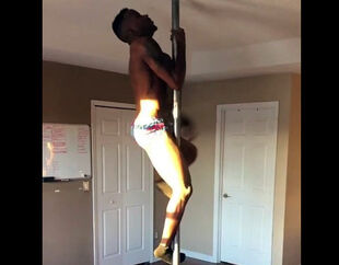 Ebony male stripper rolling on a pole.